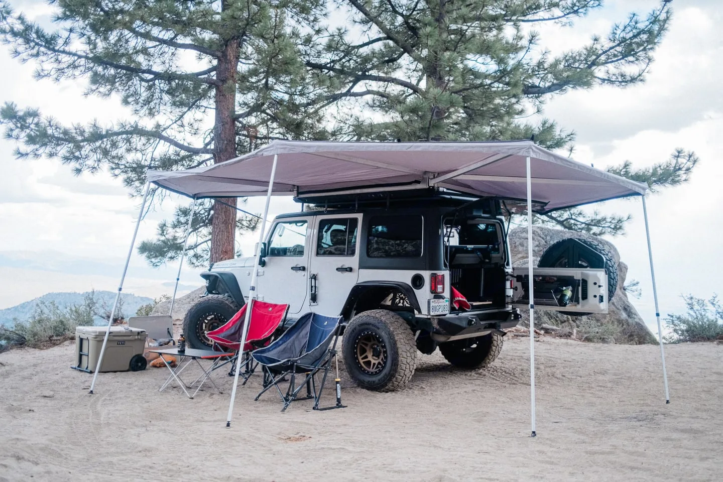 270-degree awning shading camp chairs and the tailgate kitchen at a mountain overlook